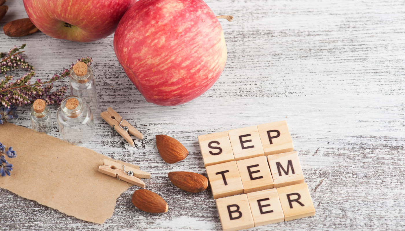 Agenda di settembre con cappello estivo e foglia d’autunno, simbolo del passaggio tra vacanze e ritorno alla quotidianità